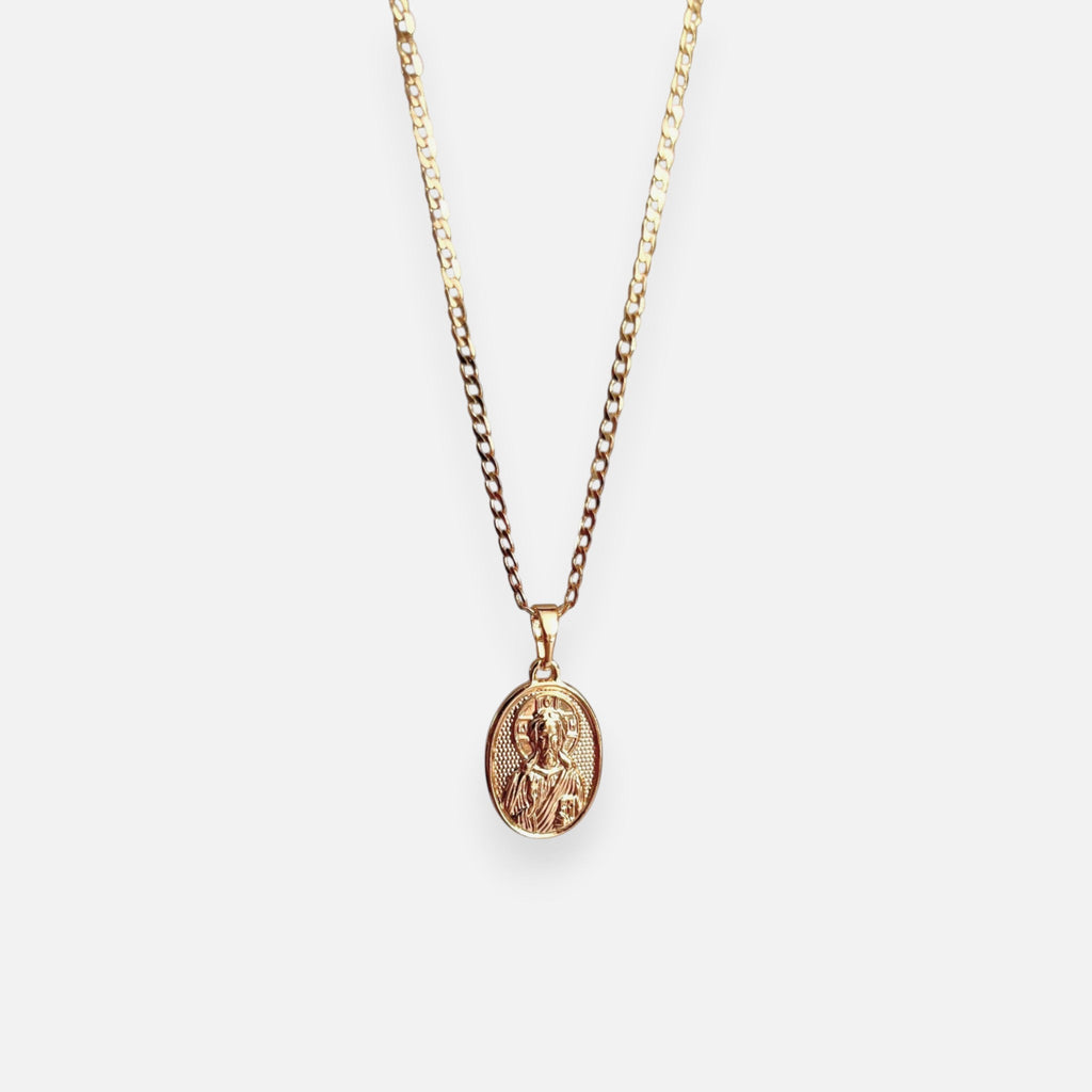 Cadena de tejido Grumet en acabado dorado, acompañada por un dije en forma de medalla ovalada. En el centro destaca la imagen en relieve de San Judas Tadeo sobre un fondo texturizado, enmarcada por un borde de perfil liso.