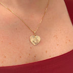 Cadena de tejido Veneciana en acabado dorado, acompañada por un dije en forma de corazón doble cara o reversible. Por una cara presenta la imagen del Sagrado Corazón de Jesús con halo radiante y por la otra la figura de la Virgen del Carmen sobre un fondo texturizado de destellos. Una pieza versátil de gran devoción y protección.