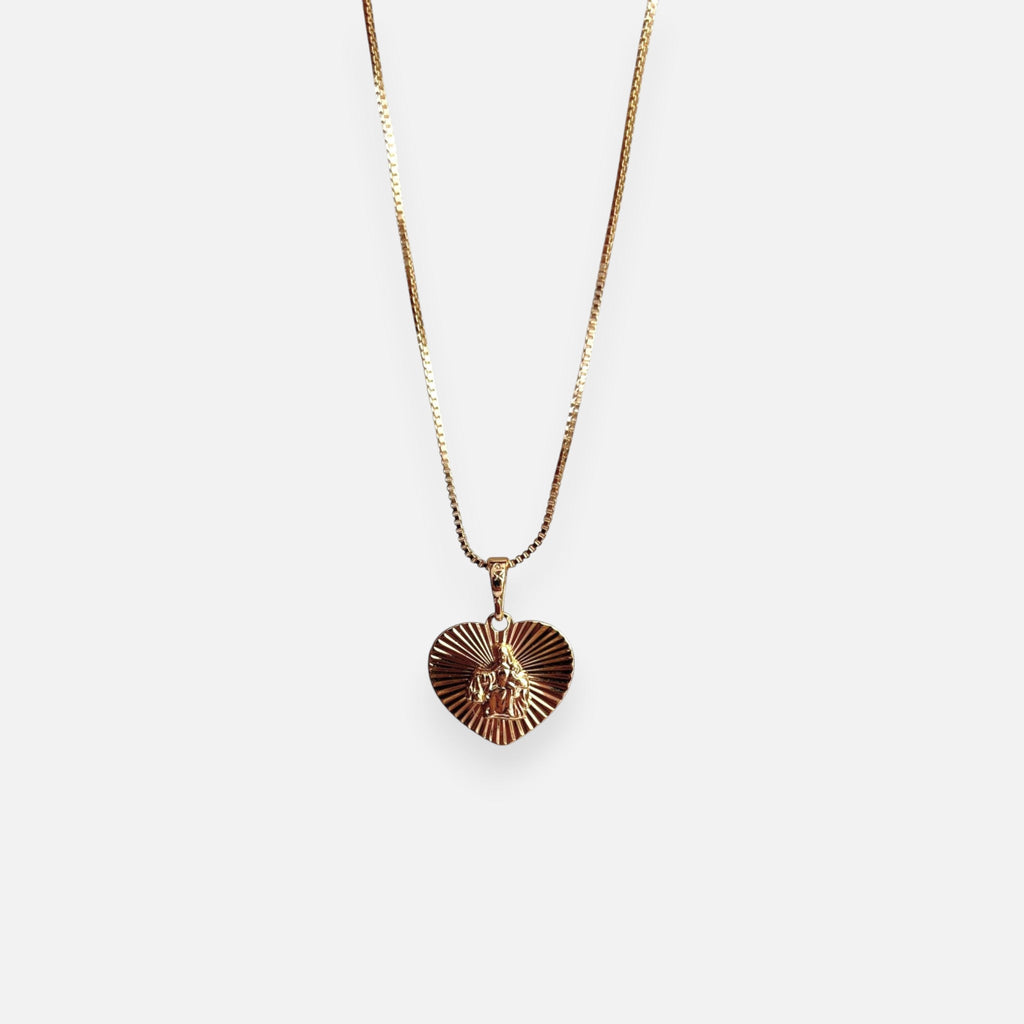 Cadena de tejido Veneciana en acabado dorado, acompañada por un dije en forma de corazón doble cara o reversible. Por una cara presenta la imagen del Sagrado Corazón de Jesús con halo radiante y por la otra la figura de la Virgen del Carmen sobre un fondo texturizado de destellos. Una pieza versátil de gran devoción y protección.