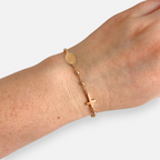 Pulsera tipo denario Hv Hermanas Villegas en oro rosé con cruz, medalla de la Virgen Milagrosa y balines brillantes.