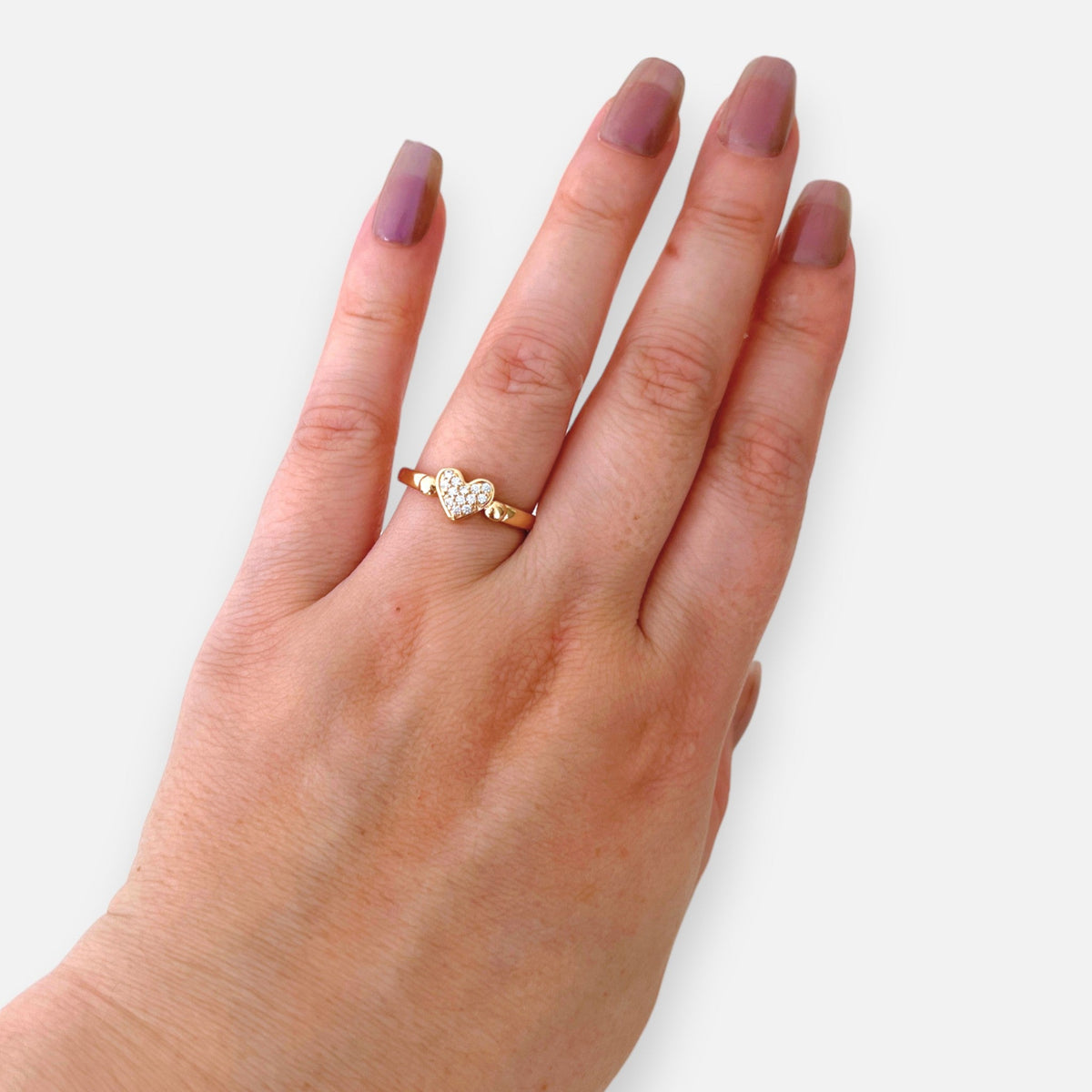 Anillo Hv Hermanas Villegas de cobre con baño oro rosé, dije de corazón con circones brillantes en mano femenina