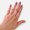 Anillo Hv Hermanas Villegas estilo corona en oro rosé con corazón central y circones brillantes en mano femenina