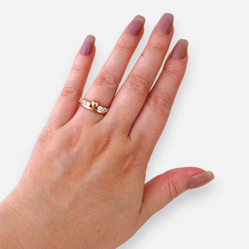 Anillo Hv Hermanas Villegas estilo corona en oro rosé con corazón central y circones brillantes en mano femenina