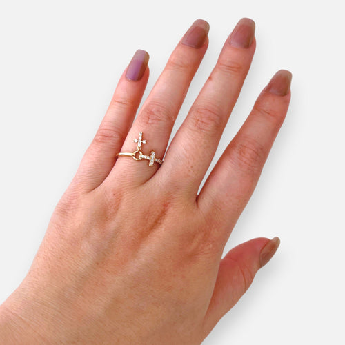 Anillo Hv Hermanas Villegas de oro rosé con dos cruces, circones brillantes y dije colgante en mano femenina