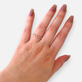 Anillo Hv Hermanas Villegas fino de oro rosé con circones y esferas metálicas en mano femenina