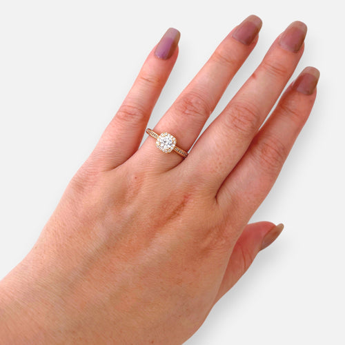 Anillo Hv Hermanas Villegas de compromiso en oro rosé con circonia central redonda y halo cuadrado en mano femenina.