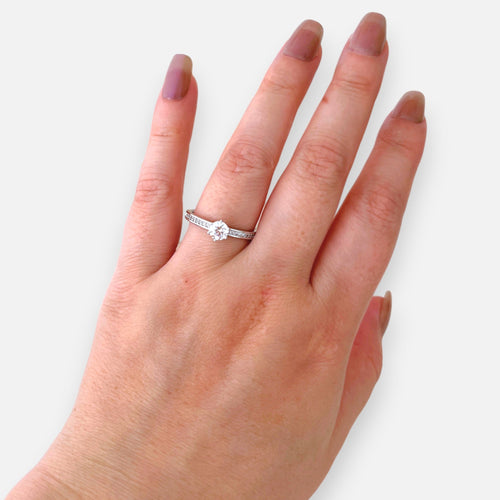 Anillo solitario Hv Hermanas Villegas de cobre con baño de rodio, circonia central y banda con pequeños circones.