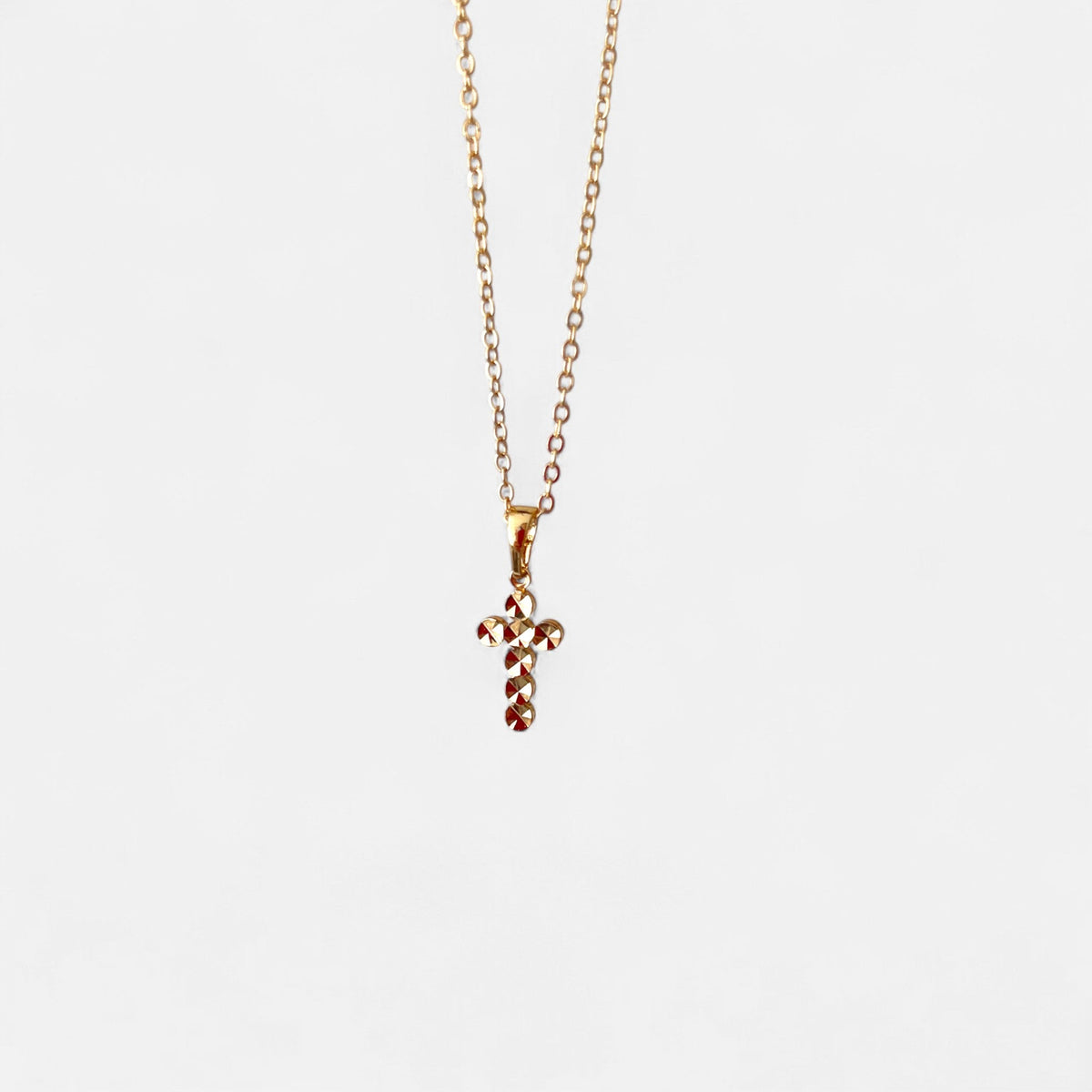 Cadena Hv Hermanas Villegas estilo forcet en cobre con baño de oro rosé y dije de cruz facetada brillante.