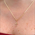 Collar Hv Hermanas Villegas con cadena de tejido lomo y dije de cruz lisa en baño de oro rosé sobre el cuello