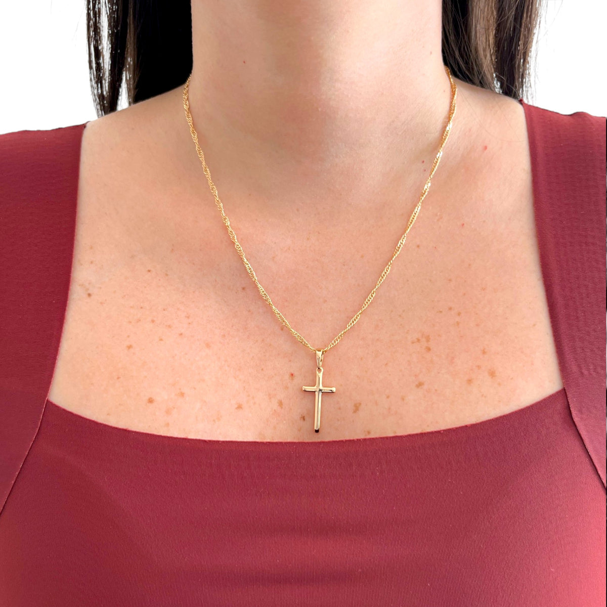 Collar Hv Hermanas Villegas con cadena Singapur y dije de cruz lisa en baño de oro rosé sobre modelo