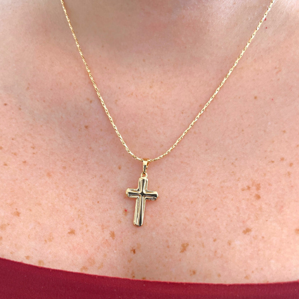 Cadena entorchada Hv Hermanas Villegas con dije de cruz clásica en baño de oro rosé sobre el cuello