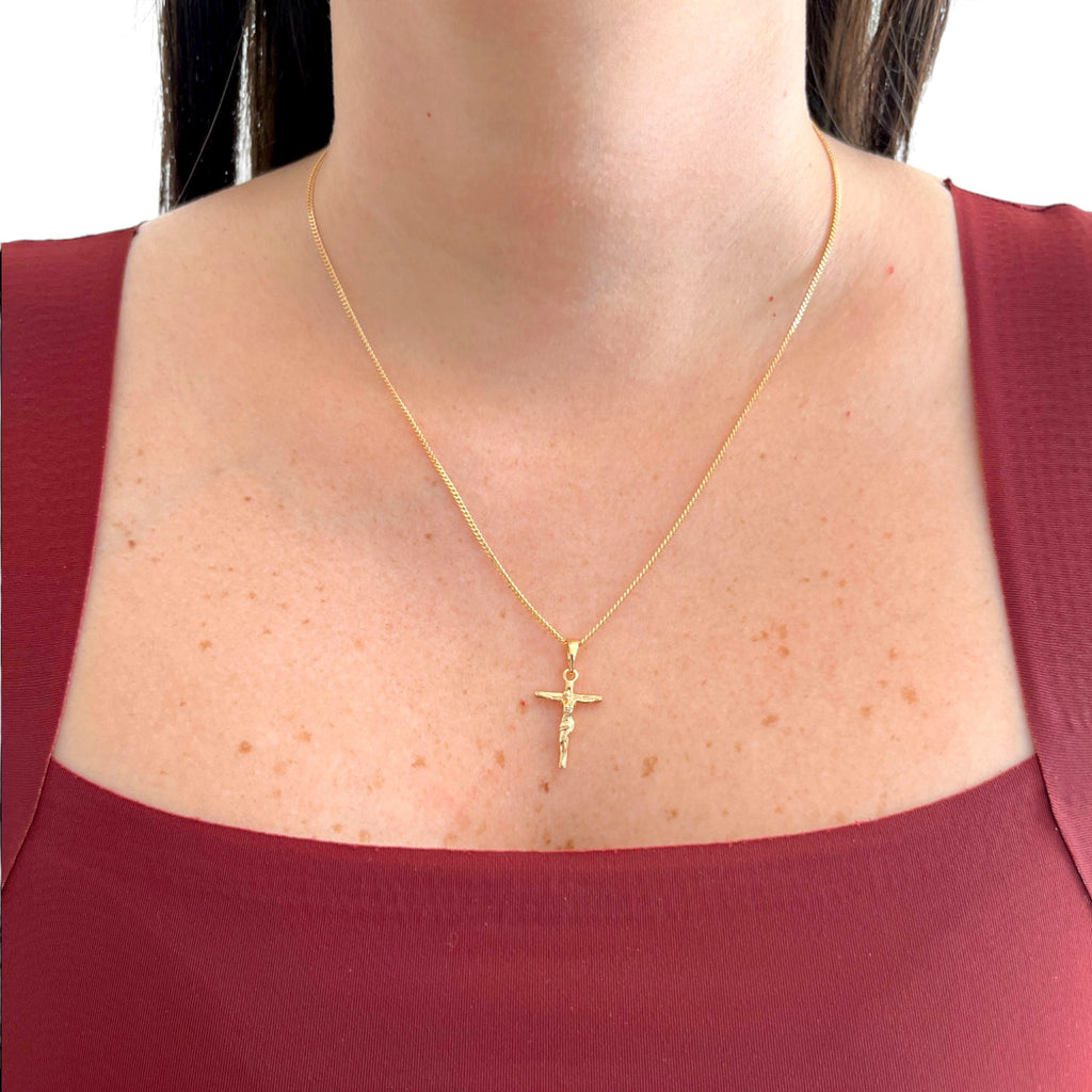Cadena Grumet Hv Hermanas Villegas con dije de crucifijo estilizado en baño de oro rosé sobre modelo