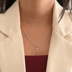 Collar Hv Hermanas Villegas de plata 925 con cadena tejido Singapur y dije de ala de ángel pulido sobre blazer beige