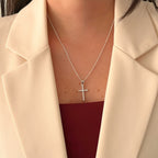 Cadena de plata 925 Hv Hermanas Villegas con dije de cruz latina y circonias brillantes sobre blazer beige