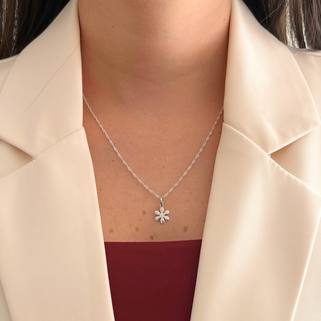 Cadena de plata 925 tejido Singapur con dije de flor lisa de Hv Hermanas Villegas sobre blazer color crema