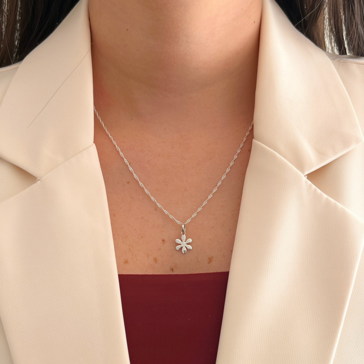 Cadena de plata 925 tejido Singapur con dije de flor lisa de Hv Hermanas Villegas sobre blazer color crema