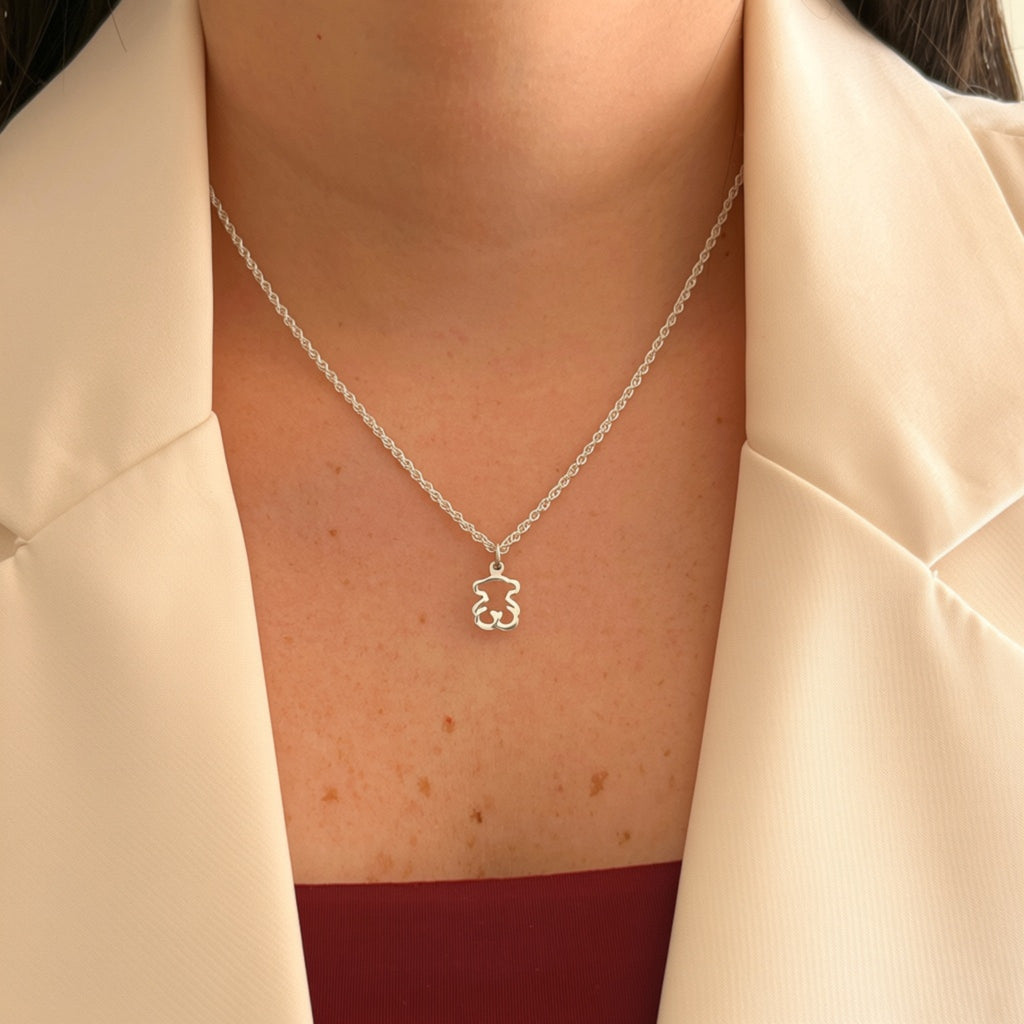 Cadena de plata 925 Hv Hermanas Villegas con dije de osito calado en tejido cordón sobre blazer beige