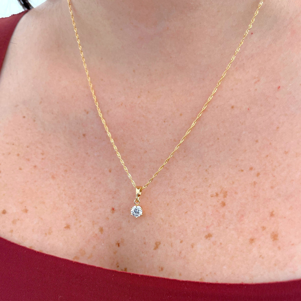 Cadena Singapur Hv Hermanas Villegas en cobre con baño de oro y dije solitario de circonia brillante en el cuello