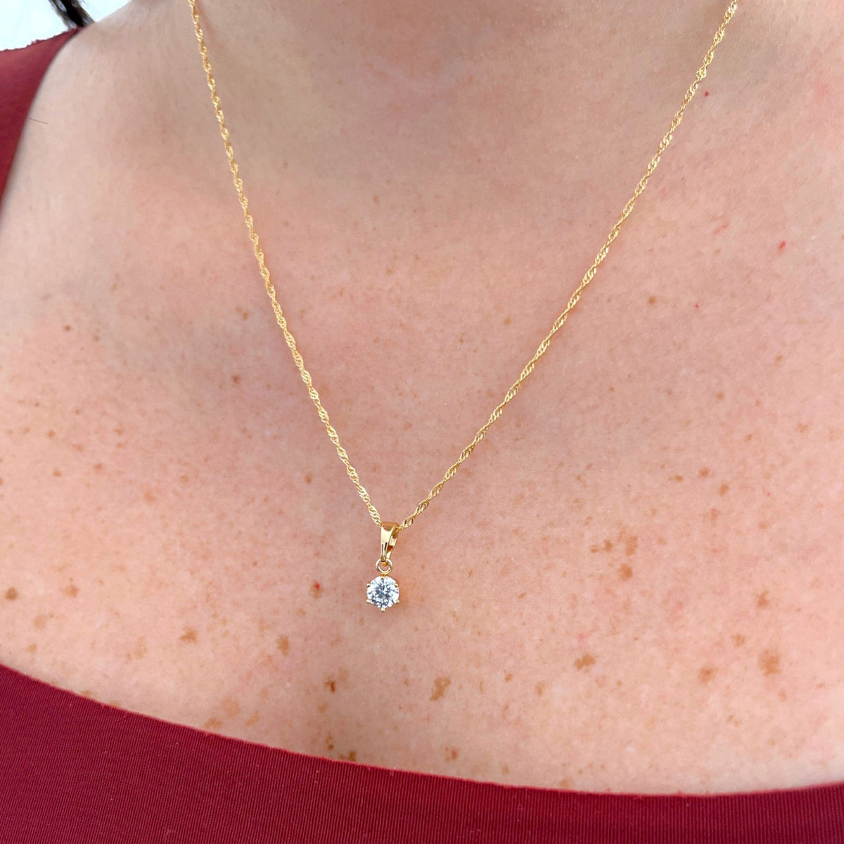 Cadena Singapur Hv Hermanas Villegas en cobre con baño de oro y dije solitario de circonia brillante en el cuello