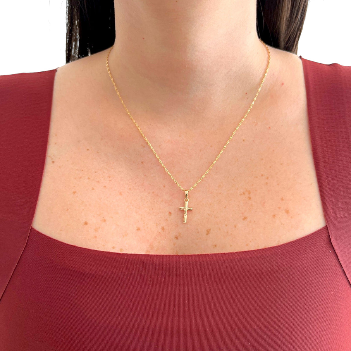 Cadena Singapur Hv Hermanas Villegas con dije de crucifijo en baño de oro rosé sobre modelo con blusa color vino