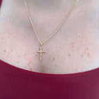 Collar Hv Hermanas Villegas con cadena veneciana y dije de crucifijo en oro rosé sobre una blusa color vino