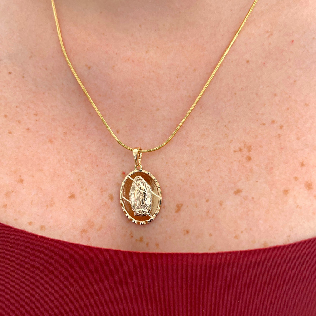 Collar Hv Hermanas Villegas con cadena cola de ratón dorada y medalla ovalada facetada de la Virgen de Guadalupe.