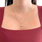 Collar Hv Hermanas Villegas con cadena anchor y dije de corazón inflado en baño de oro rosé sobre blusa granate