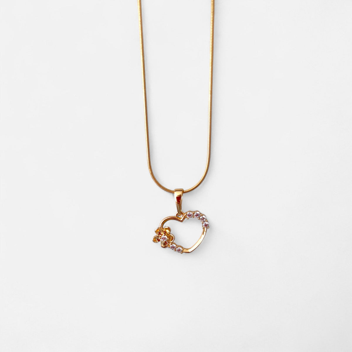 Collar Hv Hermanas Villegas estilo cola de ratón en oro rosé con dije de corazón, flor y circones brillantes.