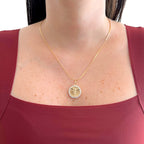 Collar Hv Hermanas Villegas con cadena anchor y medalla de Cristo en oro rosé con circonias sobre blusa granate