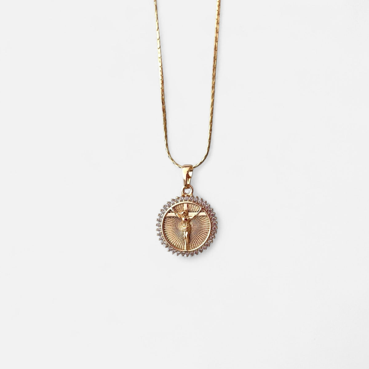 Collar Hv Hermanas Villegas con cadena anchor aplanada y medalla de Cristo en oro rosé con circonias brillantes.