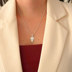 Collar Hv Hermanas Villegas de plata 925 con dije de cruz pulida y borde de circonias brillantes sobre blazer crema