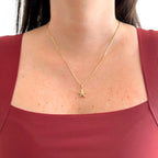 Collar Hv Hermanas Villegas con cadena veneciana y dije de estrella lisa en baño de oro rosé sobre blusa granate
