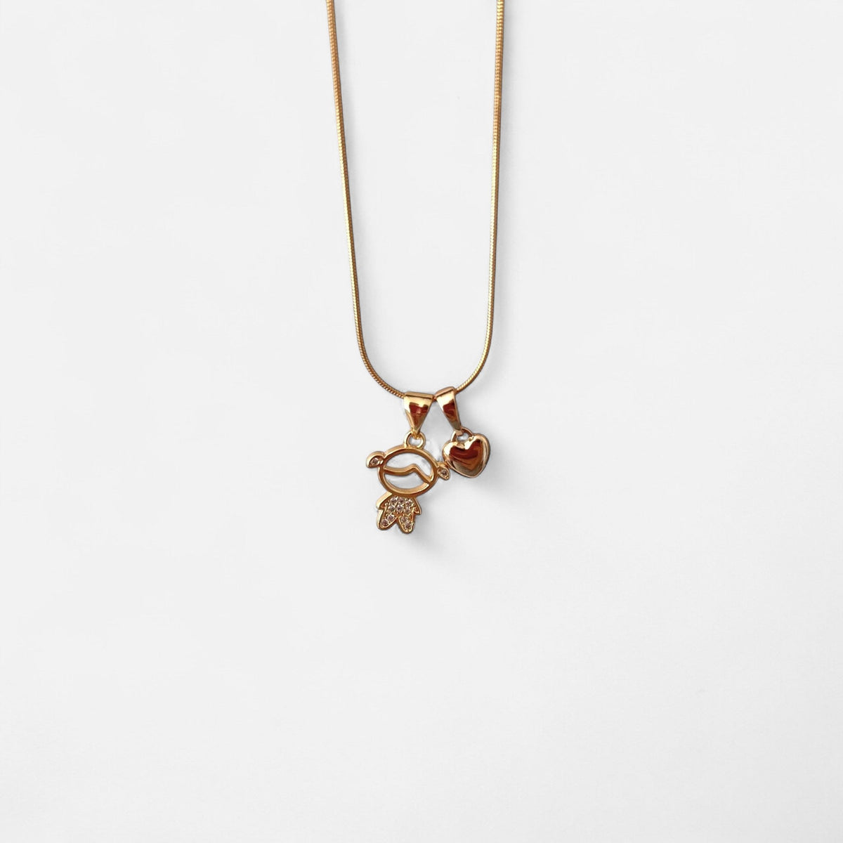 Collar Hv Hermanas Villegas de cadena cola de ratón en oro rosé con dije de niña con circonias y corazón brillante.