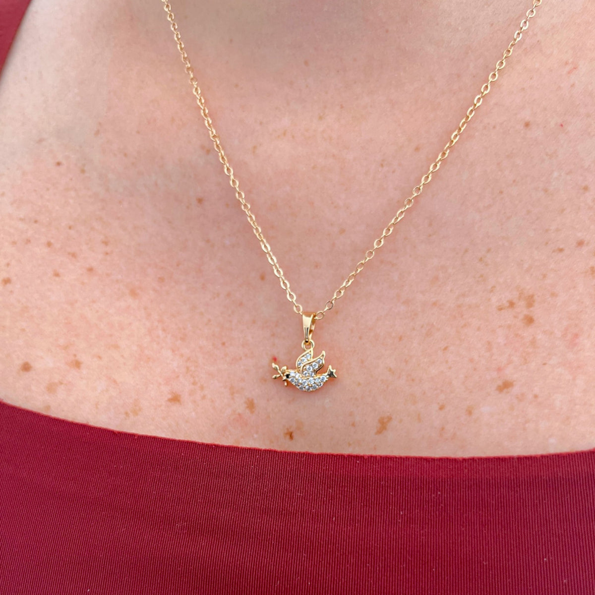 Collar Hv Hermanas Villegas con cadena force y dije de paloma en oro rosé con circonias brillantes sobre el cuello