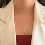 Collar Hv Hermanas Villegas de plata 925 con cadena veneciana y dije de avión minimalista sobre blazer crema