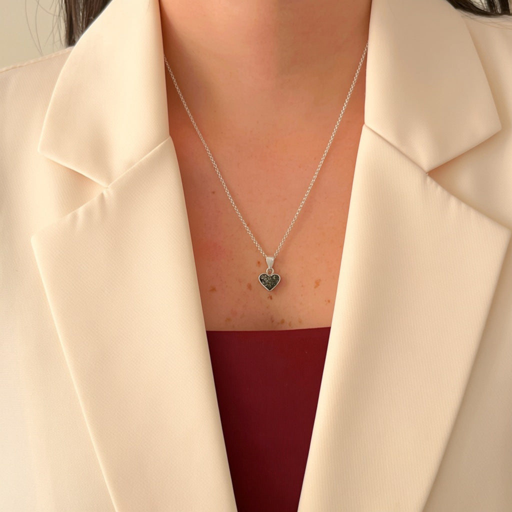 Collar Hv Hermanas Villegas de plata 925 con dije de corazón y turmalina negra sobre blazer color crema