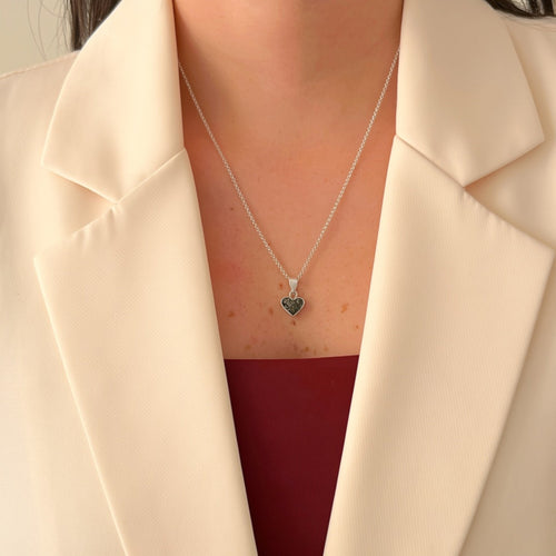 Collar Hv Hermanas Villegas de plata 925 con dije de corazón y turmalina negra sobre blazer color crema