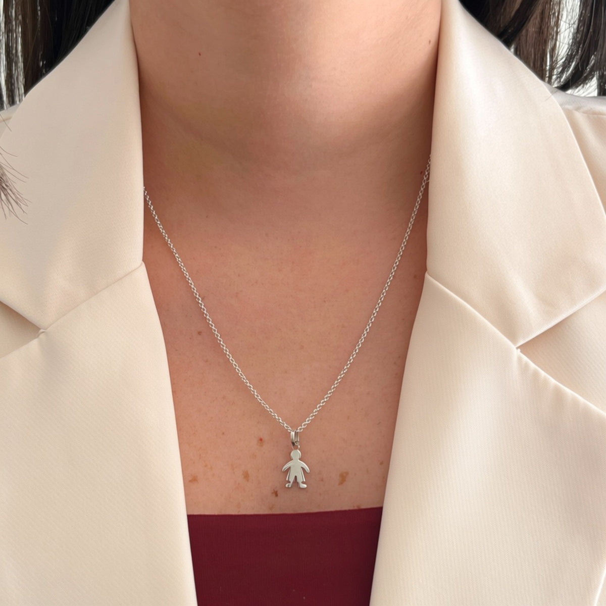 Collar Hv Hermanas Villegas de plata 925 con cadena forcet y dije de silueta de niño en acabado liso sobre blazer