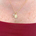 Collar Hv Hermanas Villegas con cadena grumet, medalla de la Virgen Milagrosa y cruz en oro rosé sobre fondo rojo.