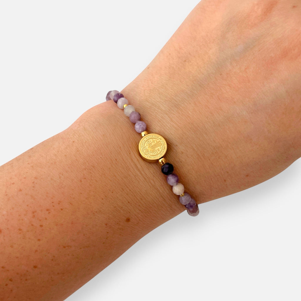 Pulsera Hv Hermanas Villegas de hilo con amatista facetada morada y medalla de San Benito en acero dorado