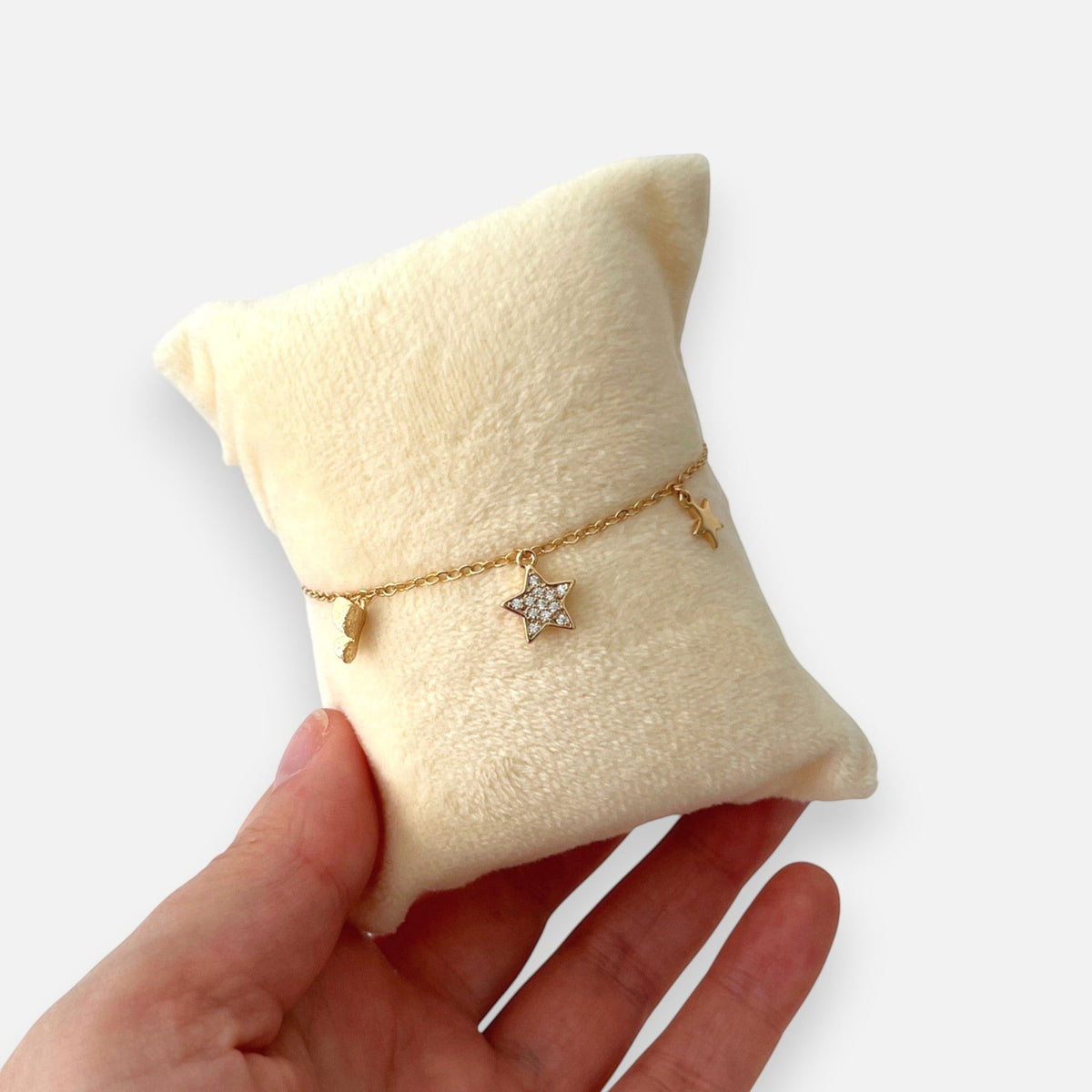 Pulsera Hv Hermanas Villegas en oro rosa con dijes de estrellas, una central con circones,