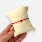 Pulsera Hv Hermanas Villegas de hilo rojo ajustable con semilla de huayruro y detalles en acero inoxidable dorado
