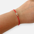 Pulsera de hilo rojo Hv Hermanas Villegas con punto de luz en oro rosa y balines decorativos