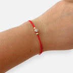 Pulsera de hilo rojo Hv Hermanas Villegas con punto de luz en oro rosa y balines decorativos