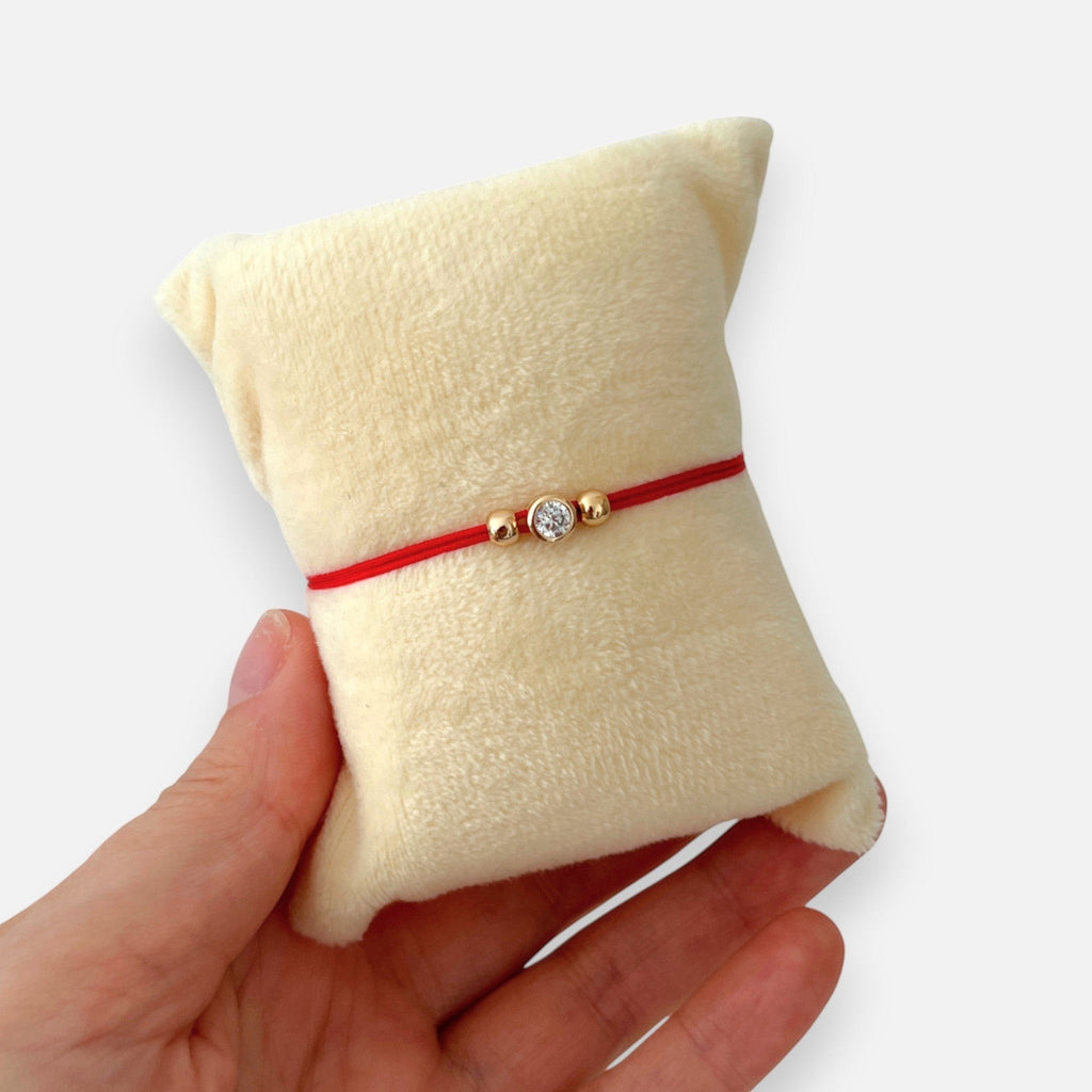 Pulsera de hilo rojo Hv Hermanas Villegas con punto de luz en oro rosa y balines