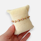 Pulsera Hv Hermanas Villegas de acero dorado con dijes de ojo turco en color rosa pastel