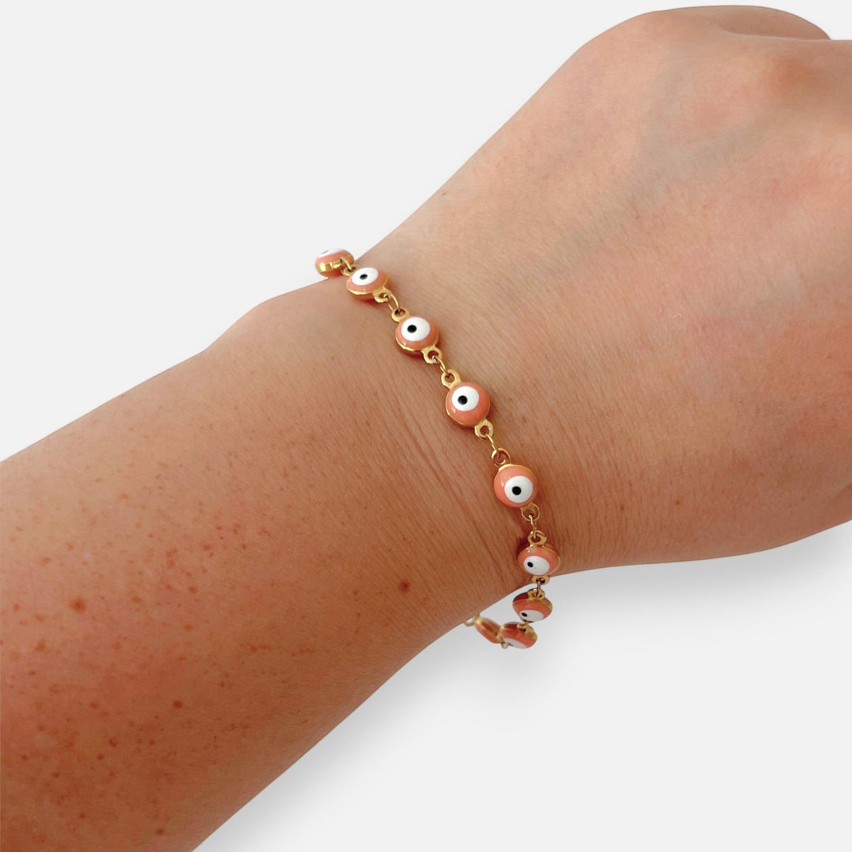 Pulsera Hv Hermanas Villegas de acero dorado con dijes de ojo turco en color rosa pastel