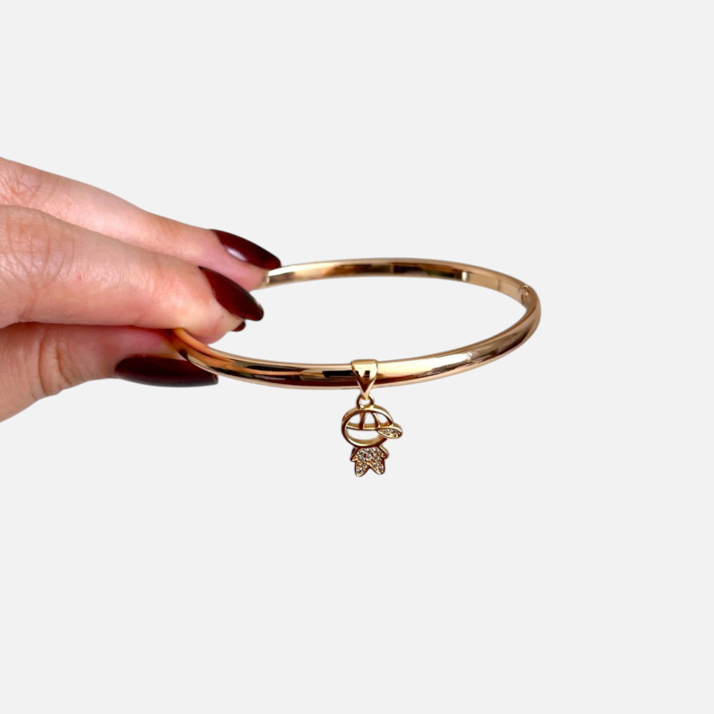 Pulsera rígida Hv Hermanas Villegas en oro rosé con dije de niño decorado con circonitas brillantes