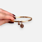 Pulsera rígida Hv Hermanas Villegas en oro rosé con medalla de la Virgen Milagrosa y dije de corazón pequeño.