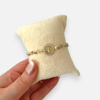 Pulsera Hv Hermanas Villegas de hilo con cuentas de Murano beige, medalla de San Benito y circones en acero dorado